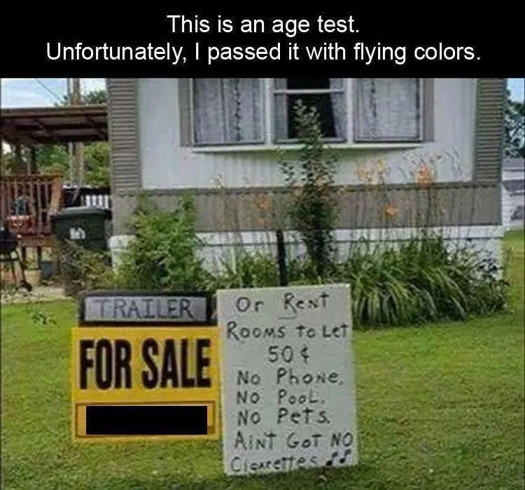 An outdoor photo shows two signs in a grassy yard in front of a house. One is a yellow 'FOR SALE' sign with 'TRAILER' above…