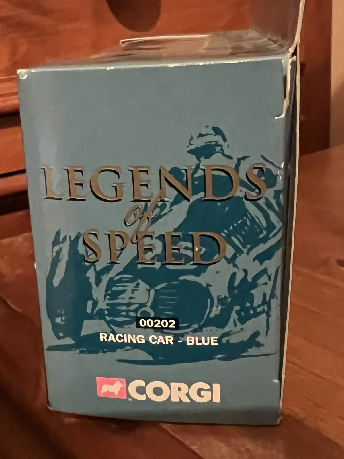 A close-up of a vintage Corgi toy car box titled 'Legends of Speed', featuring a stylized illustration of a racing car and…