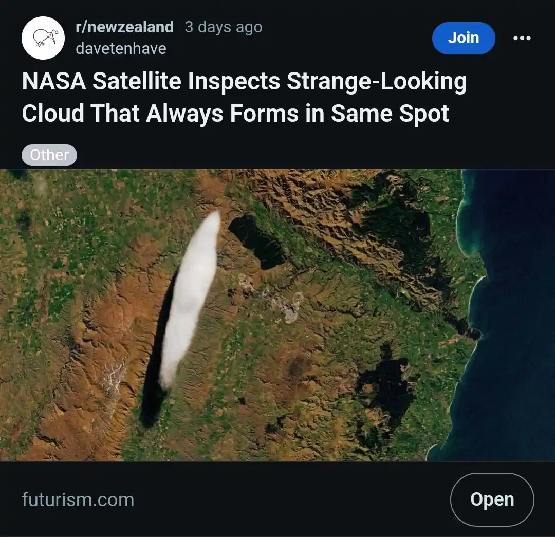 A satellite image shows a long, thin, white cloud formation resembling a feather or a blade of grass over a patch of earth…
