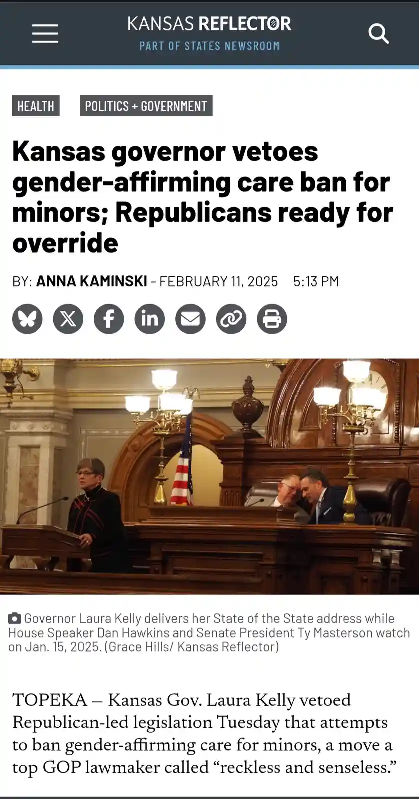 A screenshot of a Kansas Reflector news article shows Governor Laura Kelly speaking at a podium in a formal legislative…