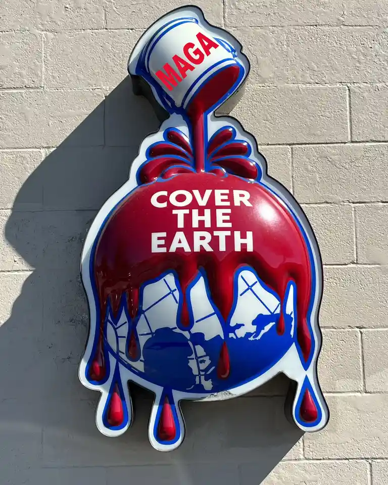 A glossy, red, white, and blue enamel sign shaped like a paint bucket pouring red paint over a globe, with 'MAGA' on the…