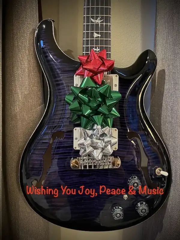 A dark purple electric guitar with a glossy finish is decorated with three large bows stacked vertically on its body: a red…