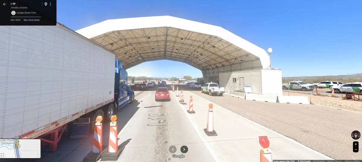 A Google Street View image from March 2024 shows a busy border patrol checkpoint on I-19 in Amado, Arizona, with cars and a…