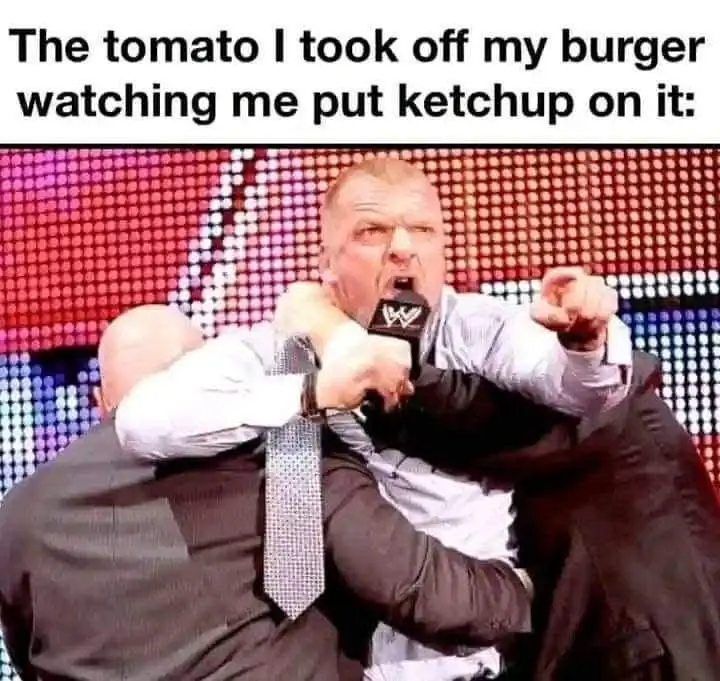 A man in a light shirt and patterned tie is being physically restrained by two other men in dark suits while holding a WWE…