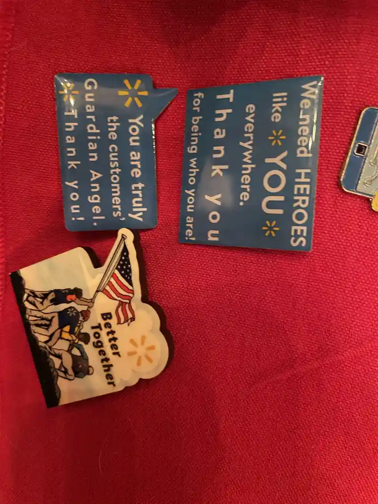 Three Walmart-themed pins lie on a red fabric surface. One pin is shaped like a speech bubble and reads 'You are truly the…