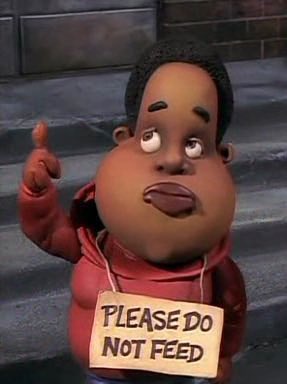 An animated character with a round face, wearing a red hoodie, holds a sign that reads 'PLEASE DO NOT FEED' while pointing…