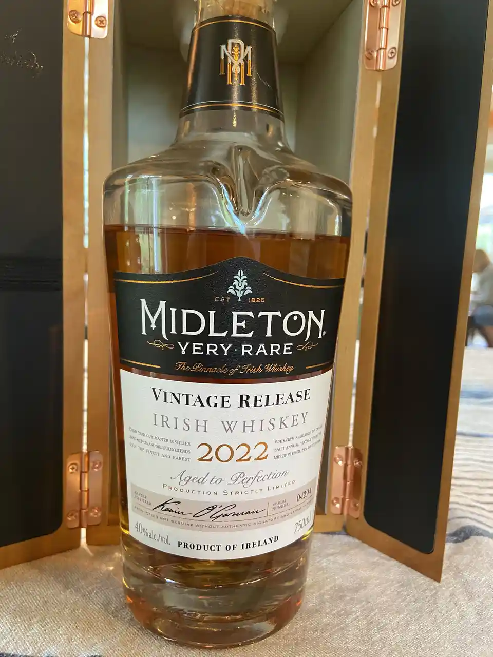 A bottle of Midleton Very Rare Irish Whiskey from the 2022 vintage is displayed in an ornate wooden presentation case with…