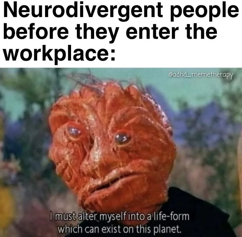 The image shows a close-up of a red, textured alien creature with large, round eyes and a grimacing expression, wearing a…
