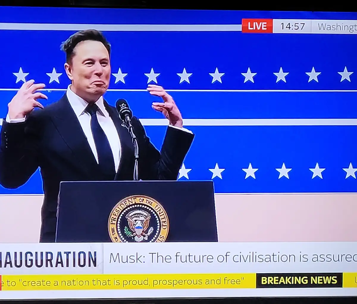 A man in a suit stands at a podium with the Seal of the President of the United States, set against a blue background with…