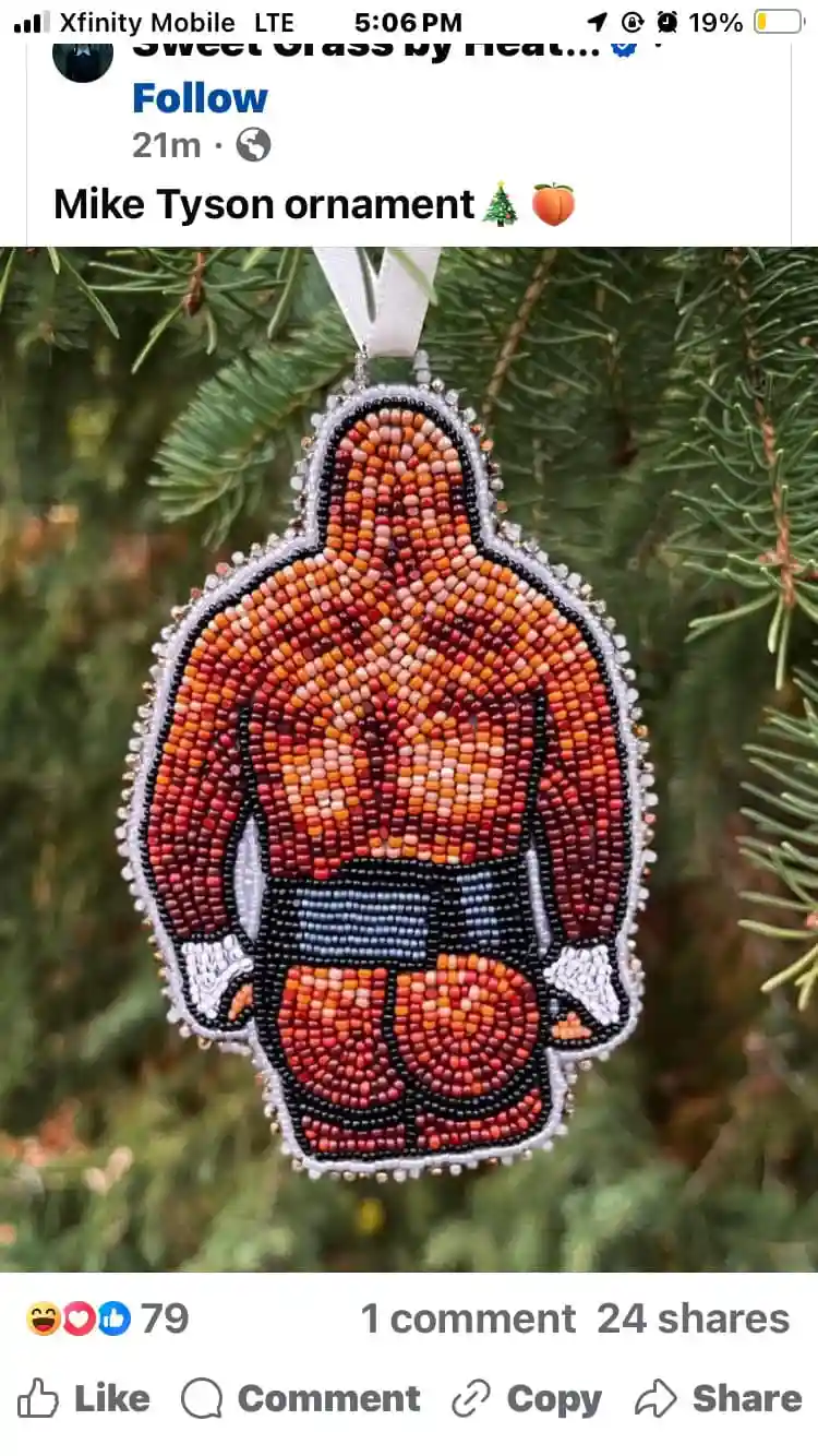 A beaded Christmas ornament shaped like Mike Tyson's muscular back, hanging on a pine tree, with the overlaid text 'Mike…