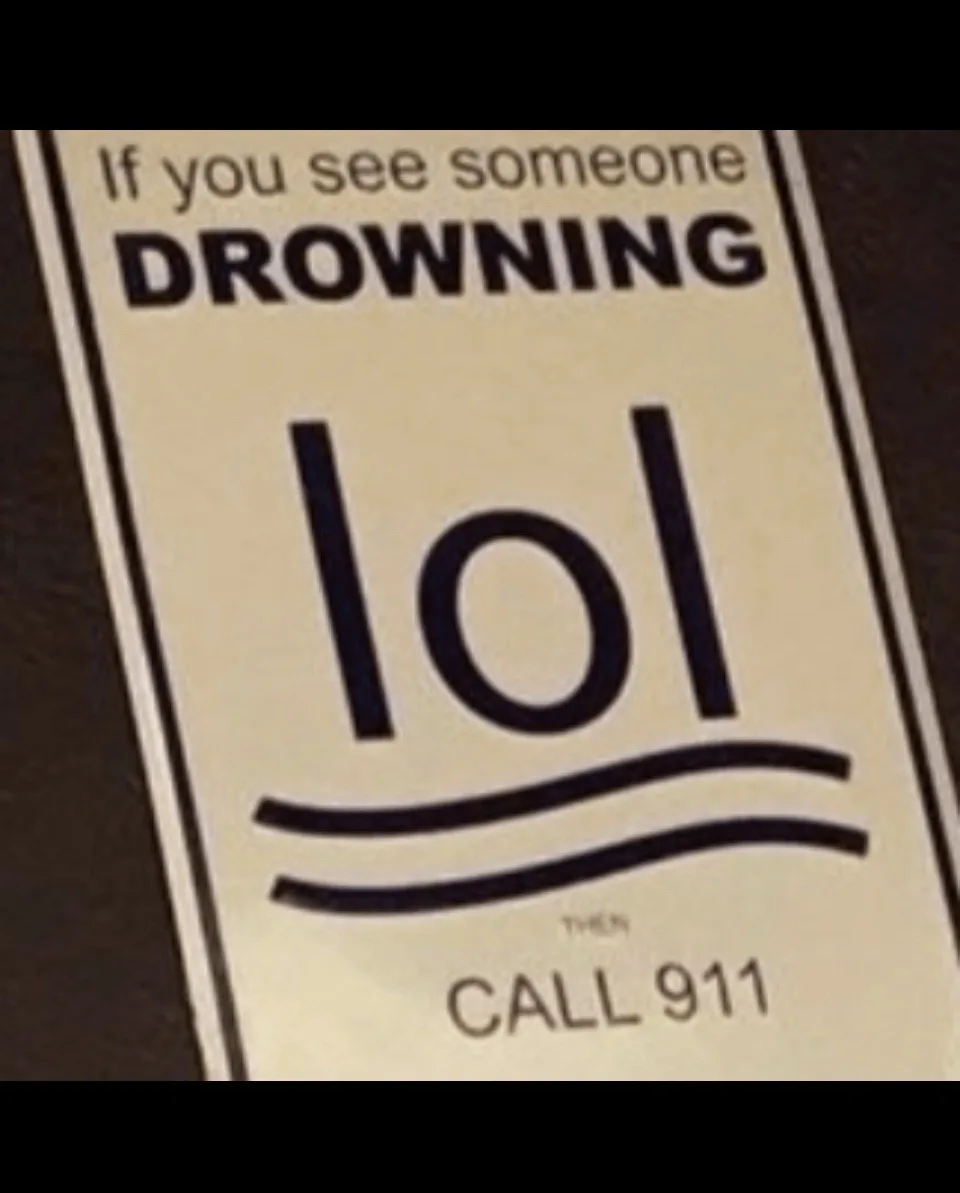 A close-up of a safety sign that reads 'If you see someone DROWNING' followed by the text 'lol' and then 'THEN CALL 911'…