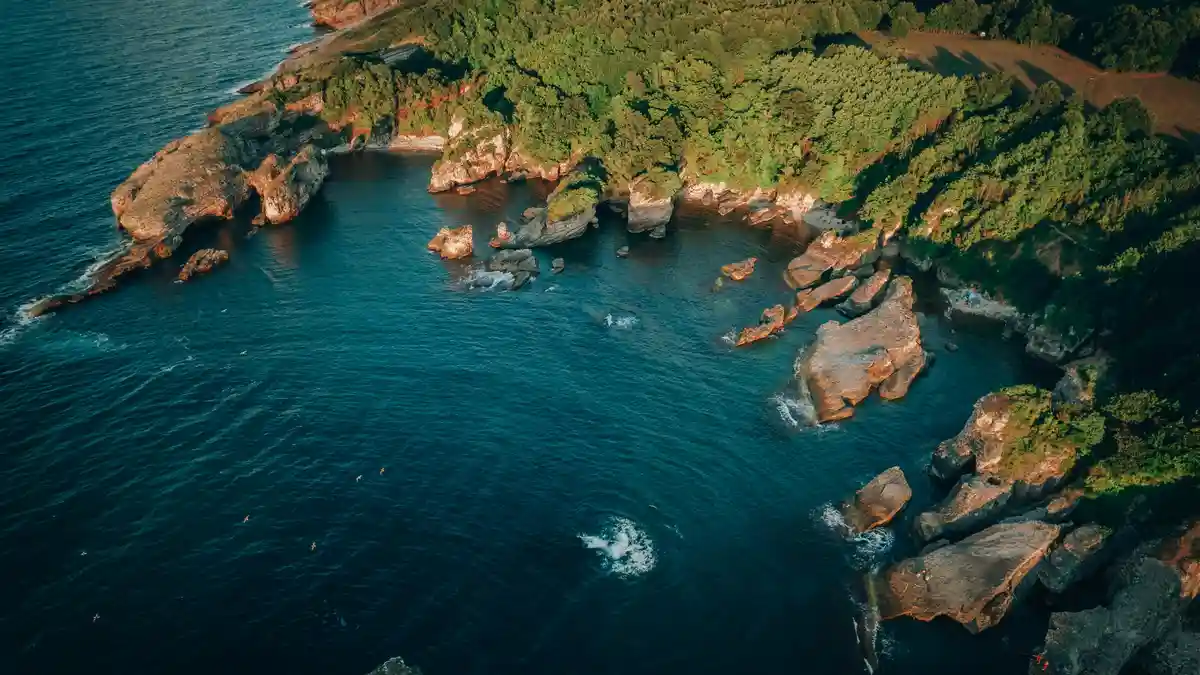 Turquoise waters lap gently against rugged shores, where granite boulders rise like sentinels from the foamy surf…