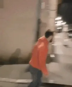A sequence of six images shows a person in an orange hoodie running down a city street at night, attempting to jump over a…