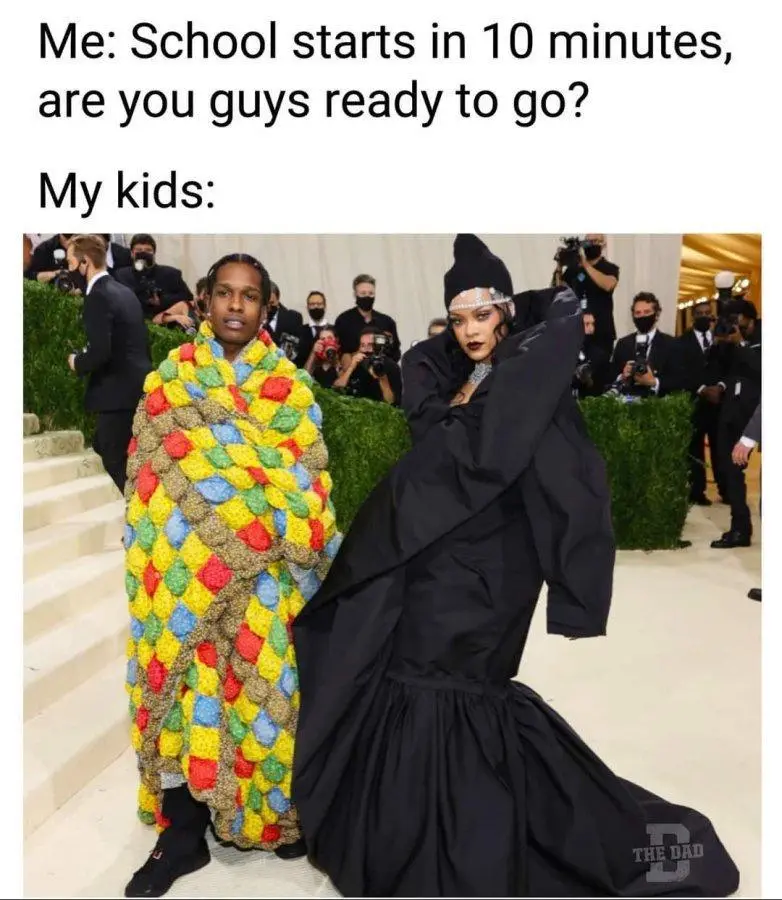 The image shows two celebrities, ASAP Rocky and Rihanna, at a red carpet event. ASAP Rocky is wrapped in a colorful…