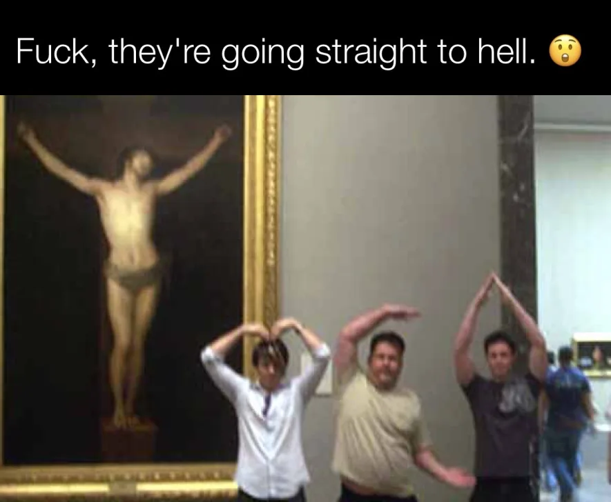 Three people are posing in front of a large painting of Jesus on the cross, making various hand gestures including a heart…