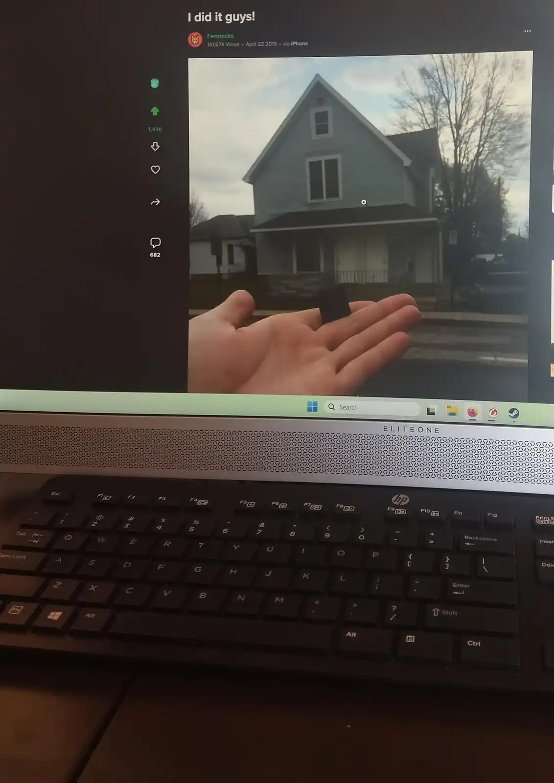 A laptop screen displays a social media post by 'Fennecks' showing a hand holding a small black object in front of a house…