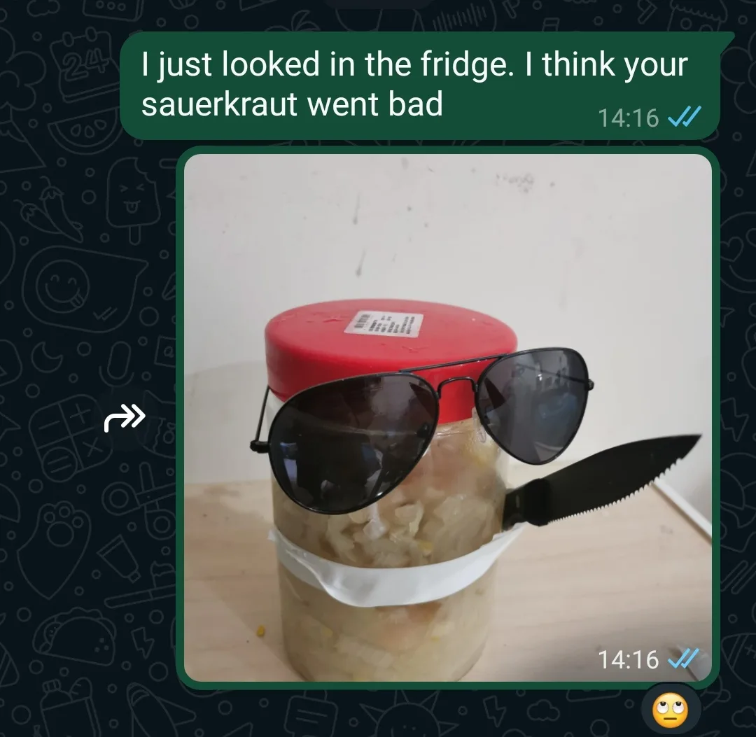 A screenshot of a WhatsApp message shows a photo of a jar of sauerkraut with a red lid, wearing black aviator sunglasses and…