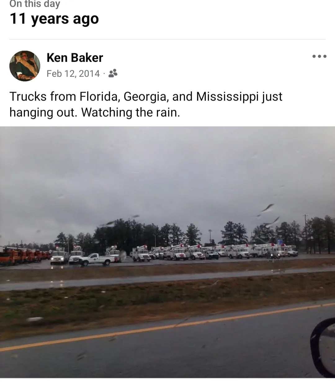 A screenshot of a Facebook post from Feb 12, 2014, by Ken Baker, showing a line of utility trucks parked in a field under a…