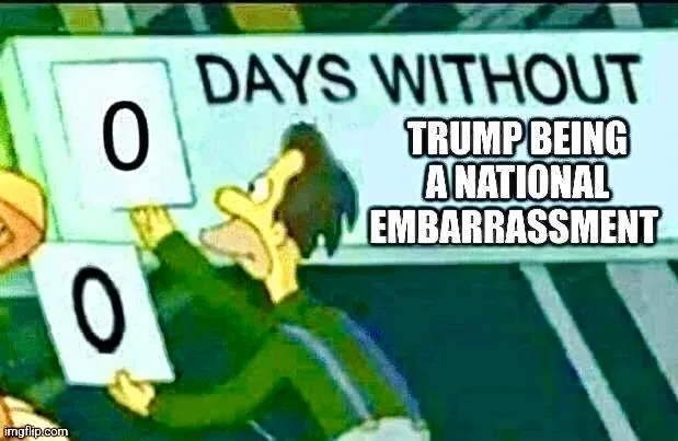 A cartoon man in a green jacket holds up two white cards with black zeros, standing before a sign that reads 'DAYS WITHOUT…