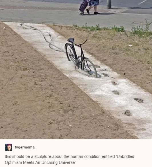 A black bicycle is embedded in a narrow concrete path, with a series of footprints leading up to it, suggesting someone…