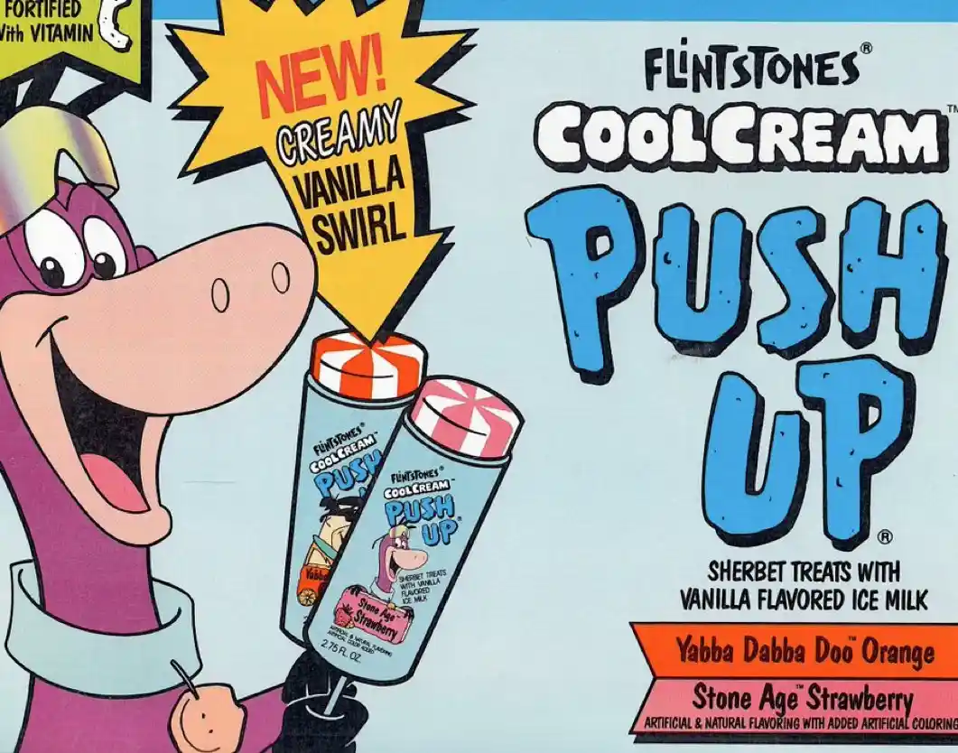 A vintage advertisement for Flintstones Coolcream Push Up sherbet treats, featuring the cartoon character Bamm-Bamm Rubble…
