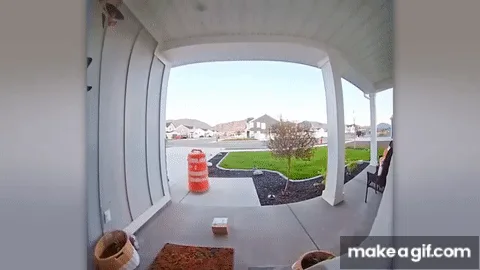 A sequence of six frames shows a large orange traffic barrel slowly rolling away from a front porch, moving from the left…