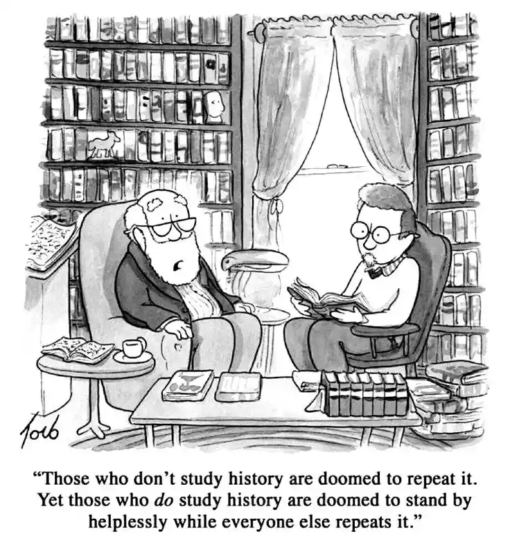 A black-and-white cartoon depicts two men in a library, surrounded by bookshelves. One older man with a beard sits in a…