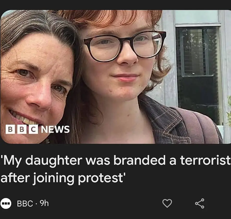 A selfie-style photo shows two women, an older woman smiling broadly on the left and a younger woman with red hair and…