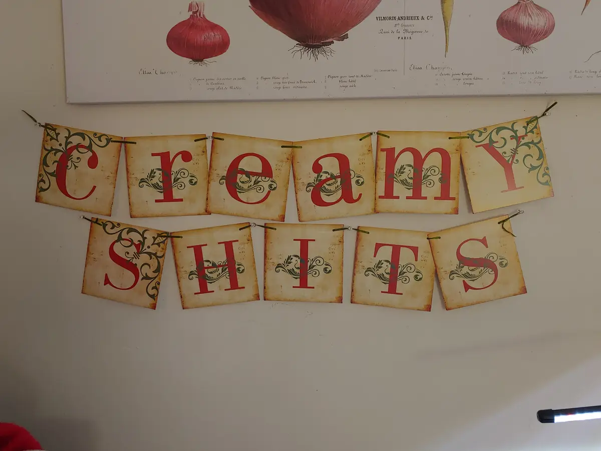 A decorative banner made of individual parchment-like flags strung together, each displaying a red letter to spell out…