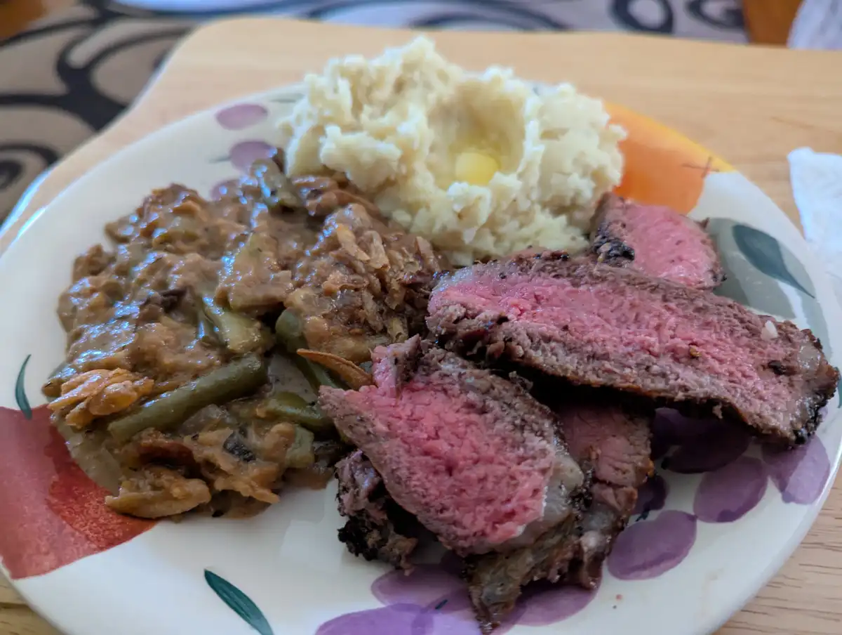 Indulge in a delicious New York Strip Steak served with creamy mashed potatoes and a savory green bean casserole