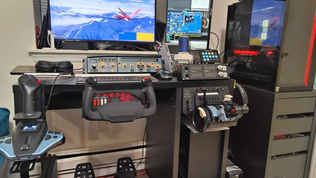 A highly customized flight simulator setup with multiple monitors, a complex array of aviation control panels, joysticks…