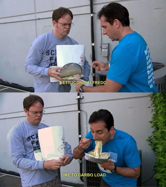 Two men stand outside, one in a grey shirt holding a large aluminum pan with a pasta dish, the other in a blue shirt. The…