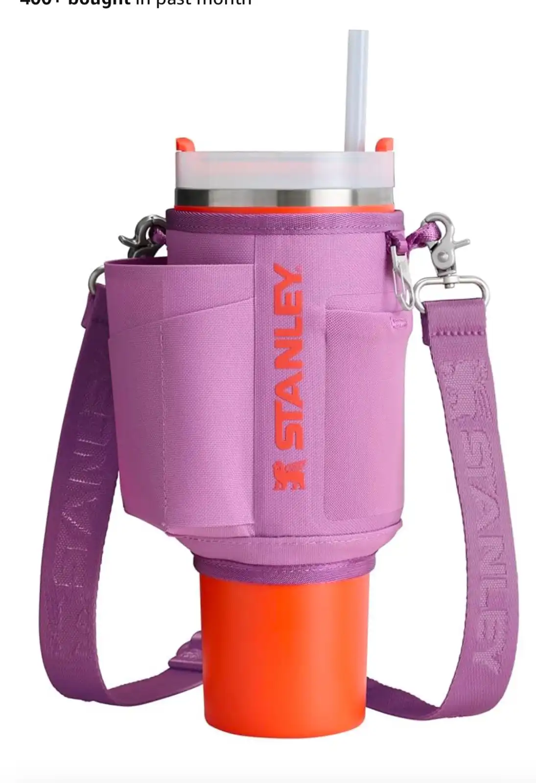 A product photo of a Stanley brand insulated tumbler with a purple neoprene sleeve and matching shoulder strap, featuring…