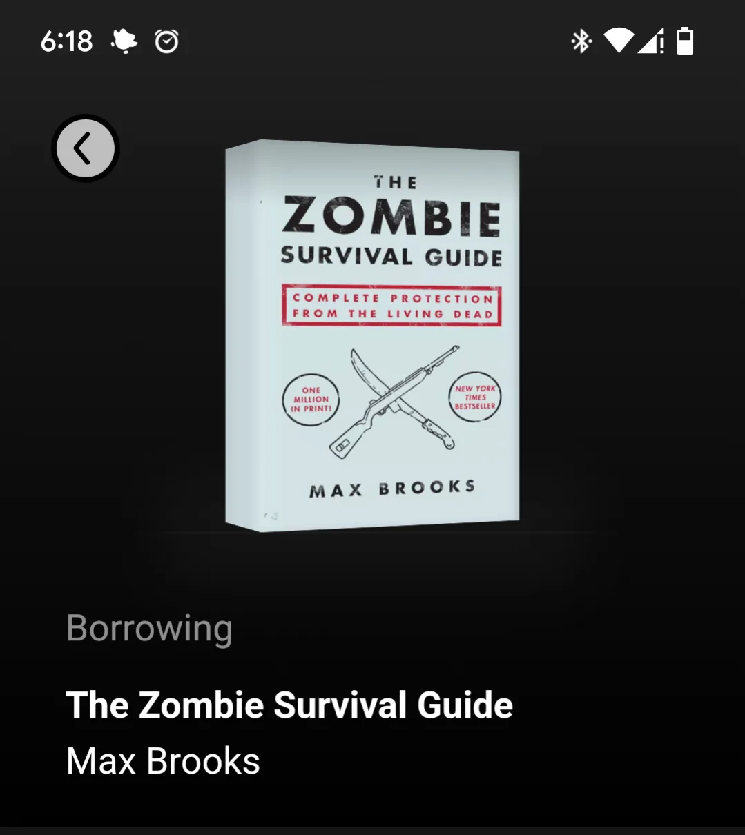 The image shows a smartphone screen displaying a book cover for 'The Zombie Survival Guide' by Max Brooks, featuring crossed…