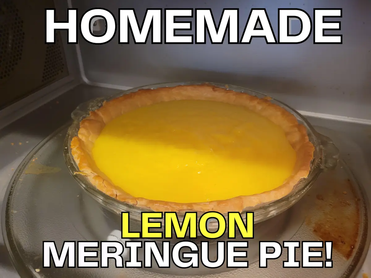 A glass dish containing a lemon meringue pie sits inside a microwave, with the words 'HOMEMADE' at the top and 'LEMON…