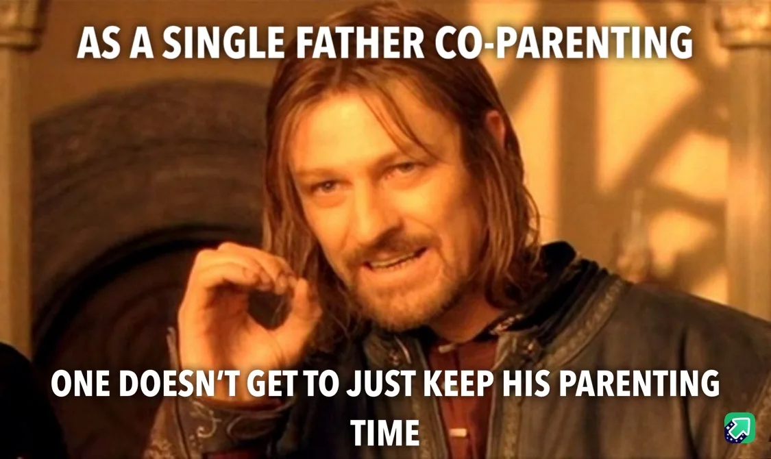 A man with long brown hair and a beard, wearing a dark jacket, looks at the camera with a knowing smirk while holding up a…