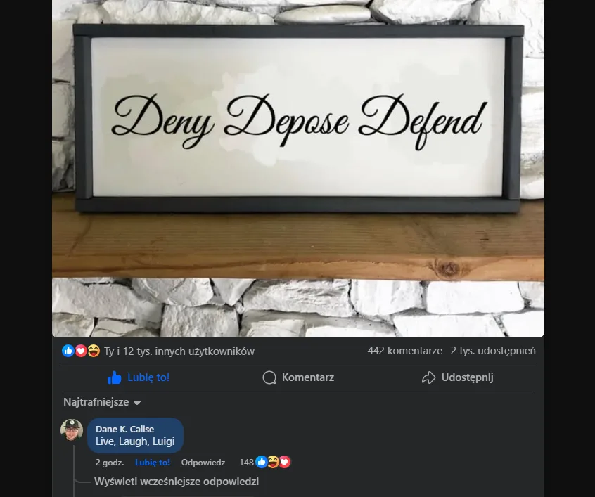 A framed sign with the words 'Deny Depose Defend' in cursive script sits on a wooden shelf against a stone wall. Below, a…