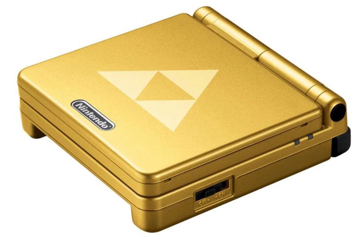 a gold-colored nintendo game console with a triforce symbol on the lid, overlaid with the text 'the golden triforce'.
