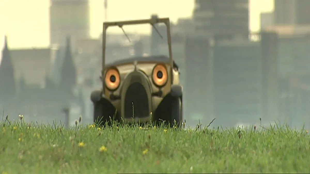 A vintage, olive-green, open-top car with cartoonishly large, glowing orange eyes is positioned on a grassy field with a…