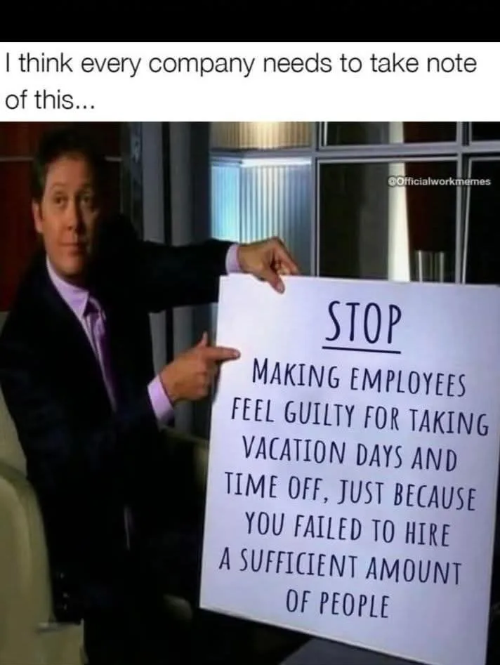 A man in a suit holds a white sign that reads 'STOP MAKING EMPLOYEES FEEL GUILTY FOR TAKING VACATION DAYS AND TIME OFF, JUST…