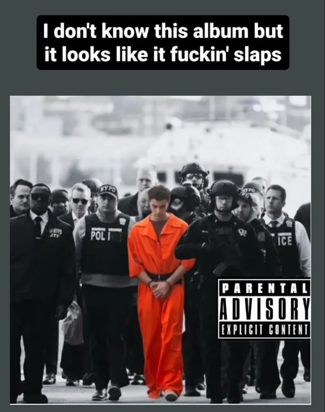 A black-and-white photo shows a young man in an orange prison jumpsuit being escorted by multiple police officers, some in…