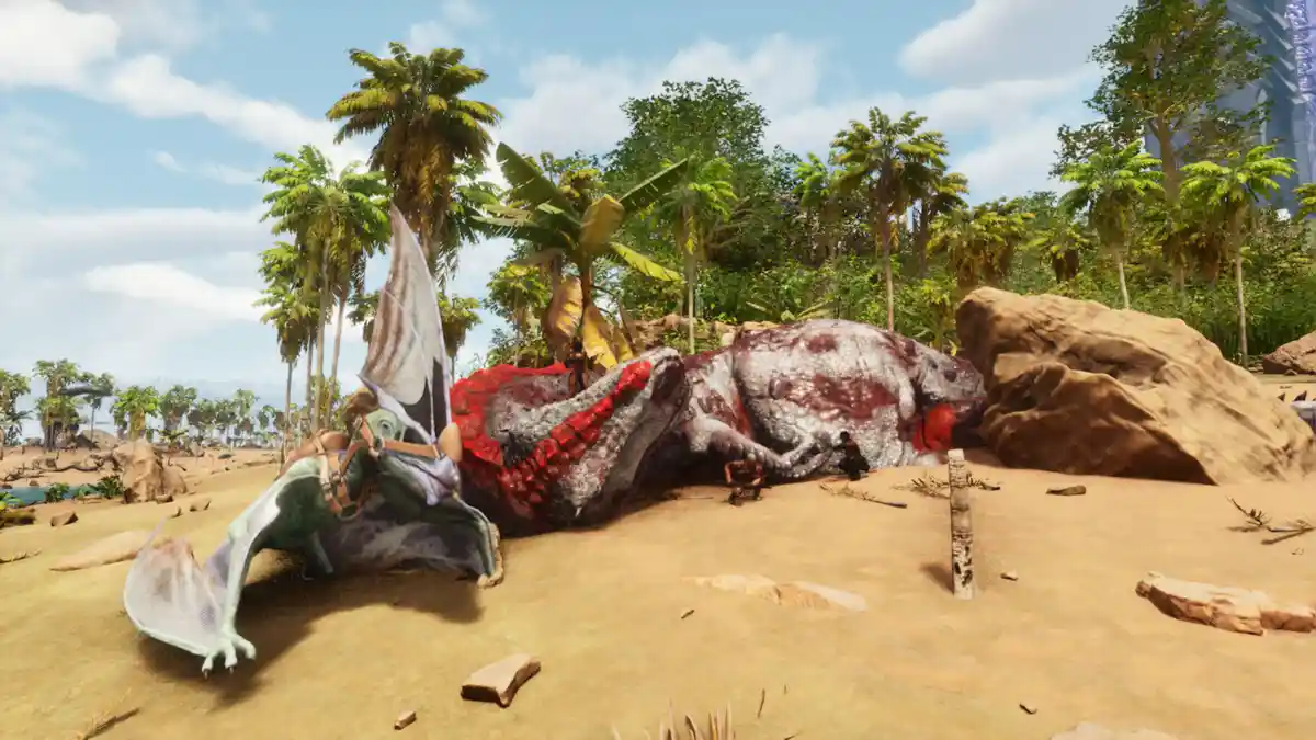 A screenshot from a video game shows a large, deceased dinosaur lying on its side in a sandy, tropical environment with palm…
