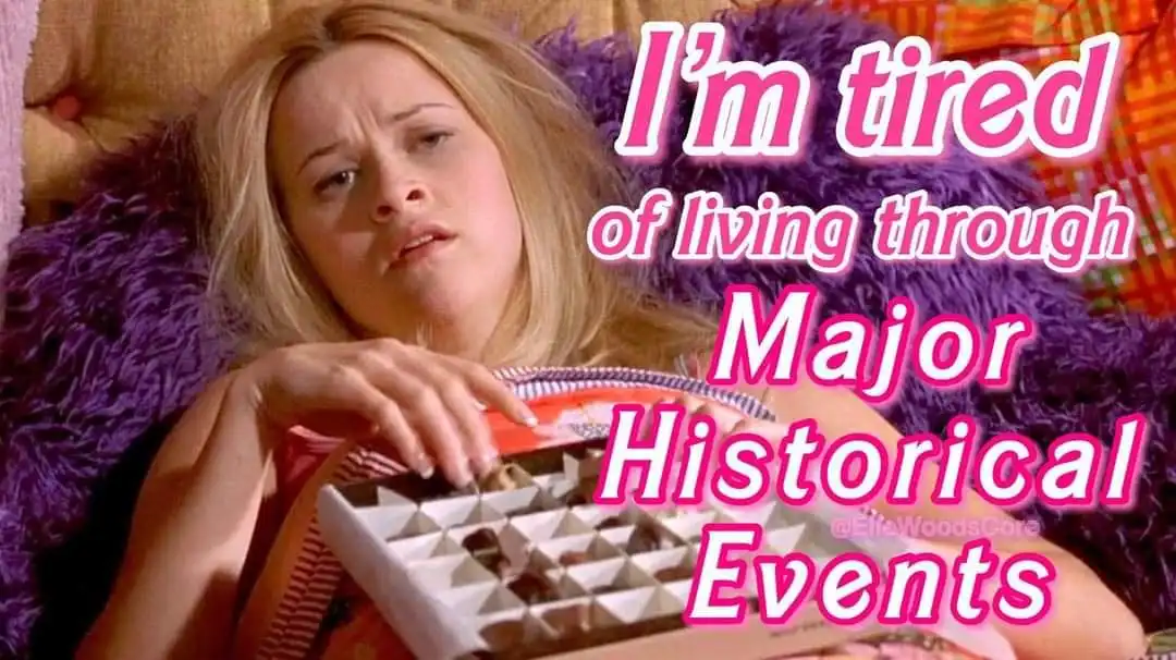 A woman with blonde hair lies on a purple fluffy pillow, looking exhausted while holding a box of chocolates. Overlaid pink…