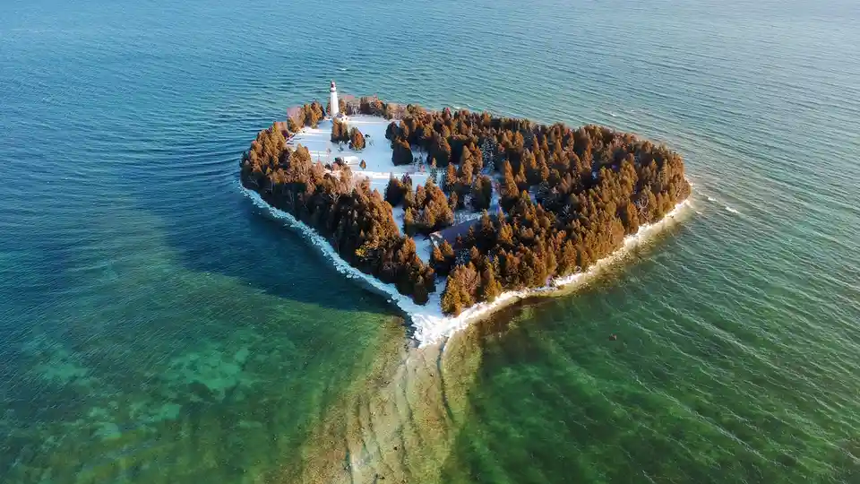 From this bird's-eye view of Cana Island, a snow-covered shape resembles a heart. The snowpoint at the island's bottom…