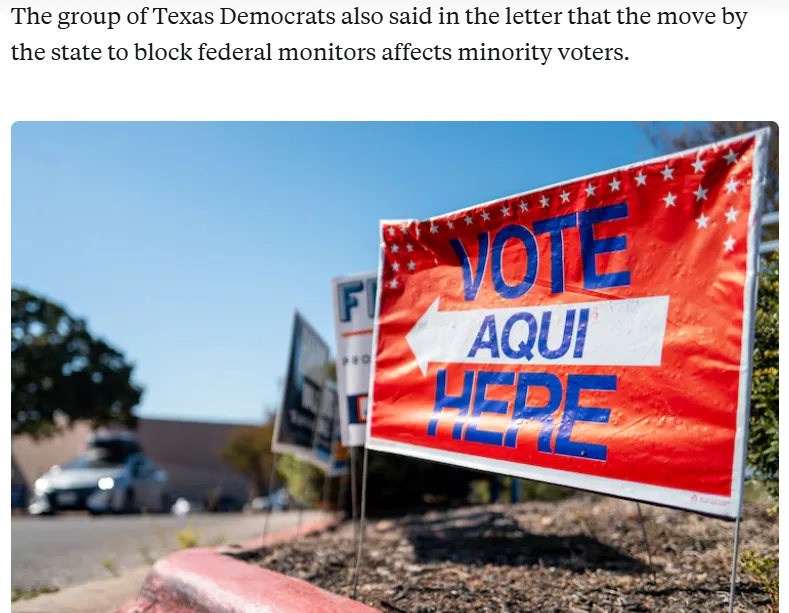 A red outdoor voting sign with blue text reading 'VOTE AQUI HERE' and a white arrow pointing left, set in a sunny outdoor…