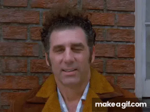 A six-panel gif shows a man in a brown coat standing in front of a brick wall. In the first frame, he smiles confidently. In…