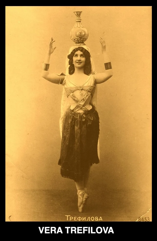 A vintage sepia-toned photograph shows a woman in an ornate, possibly Middle Eastern-inspired costume, balancing a…