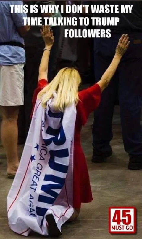 A person with blonde hair, wearing a red dress and kneeling on a floor, has a large white banner draped over their shoulders…