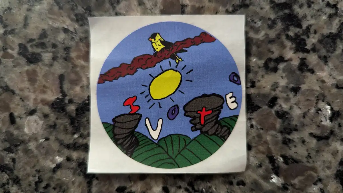 A circular sticker depicts a cartoon scene with a yellow sun, a bird perched on a red branch, and green hills. The word 'I…