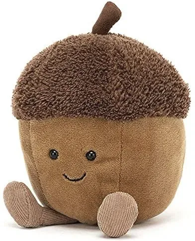 A plush toy shaped like a smiling acorn with a fuzzy brown cap, black button eyes, and small corduroy limbs, sitting…